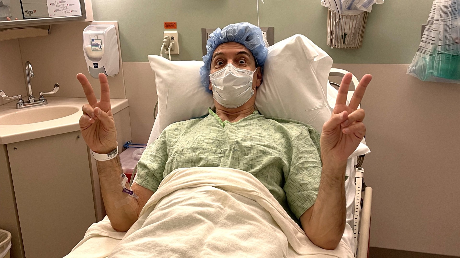 Jonathon Brandmeier makes the peace sign from his hospital bed.