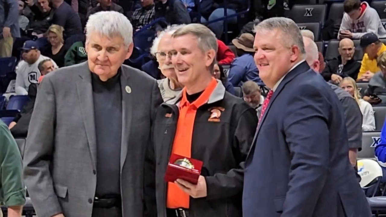 Greg Smallwood receives an award during basketball game