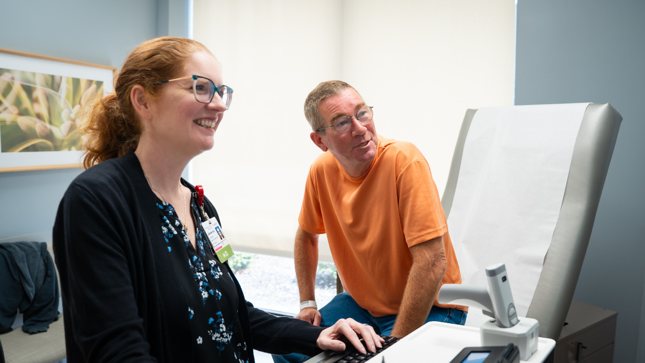 Jeff and Dr. Leddon review his lung scans in an exam room at the UC Cancer Center.