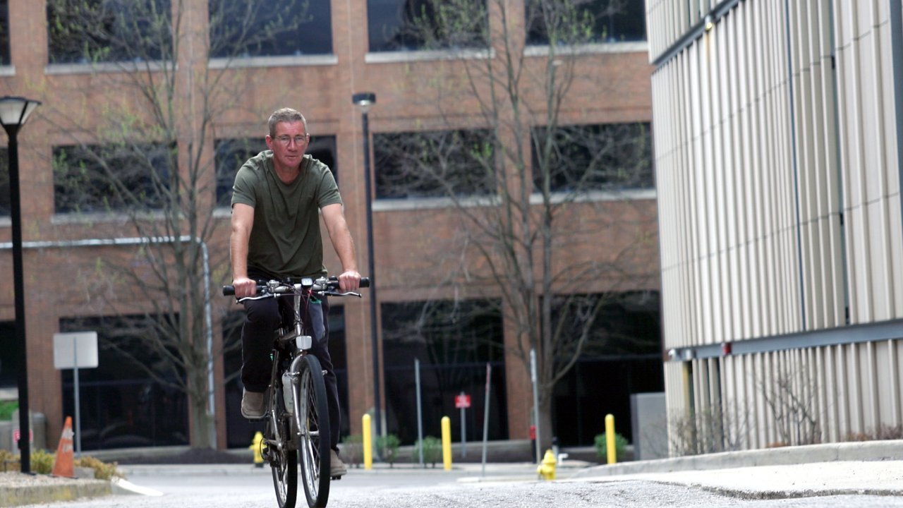 UC Cancer Center patient, Jeff, rides his bike at the Cincinnati campus.