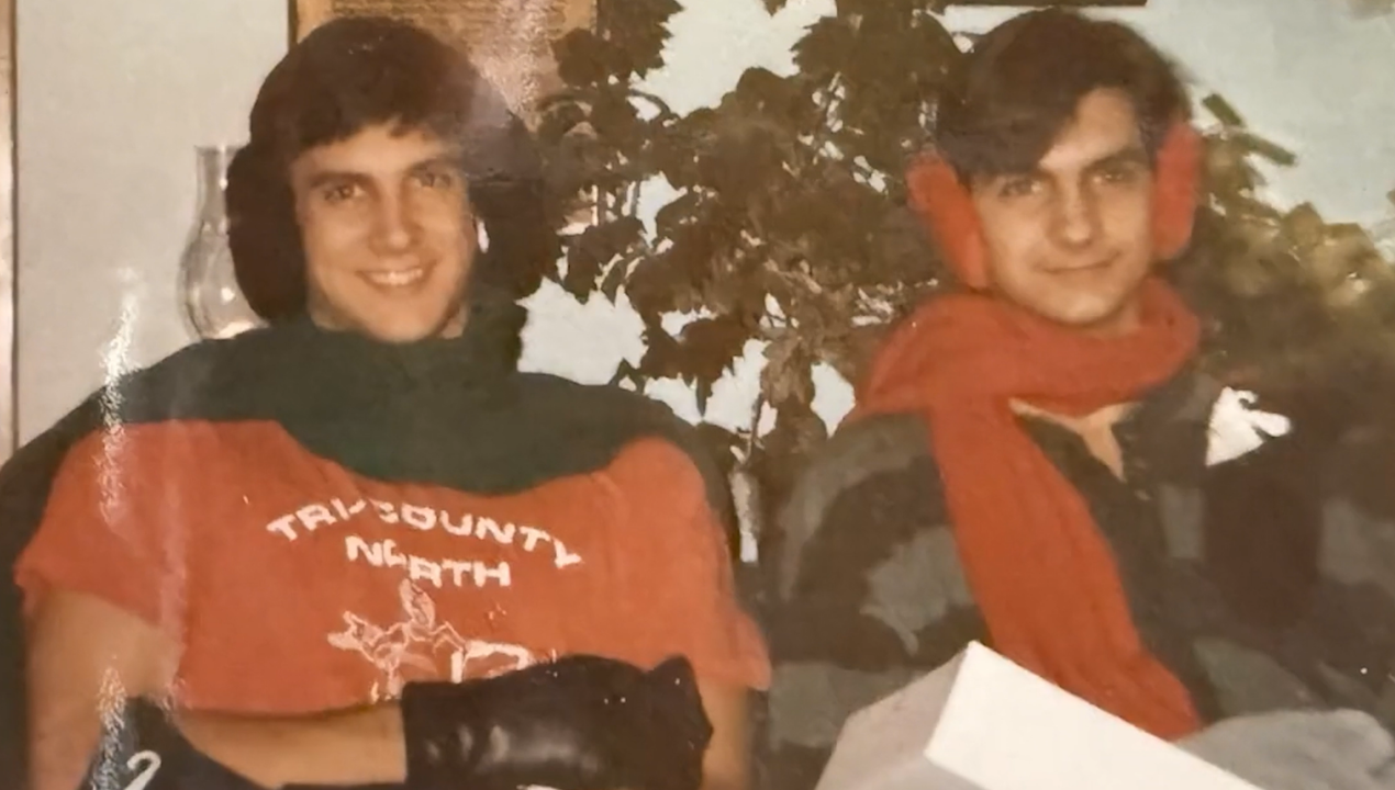 Ken and Matt Gauvey in an older family photo smiling together with earmuffs on
