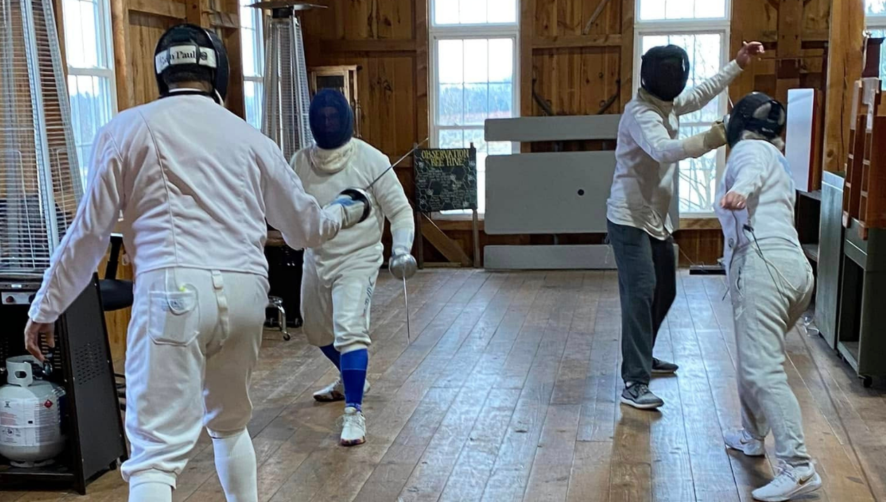 Ken and his fencing team practicing indoors