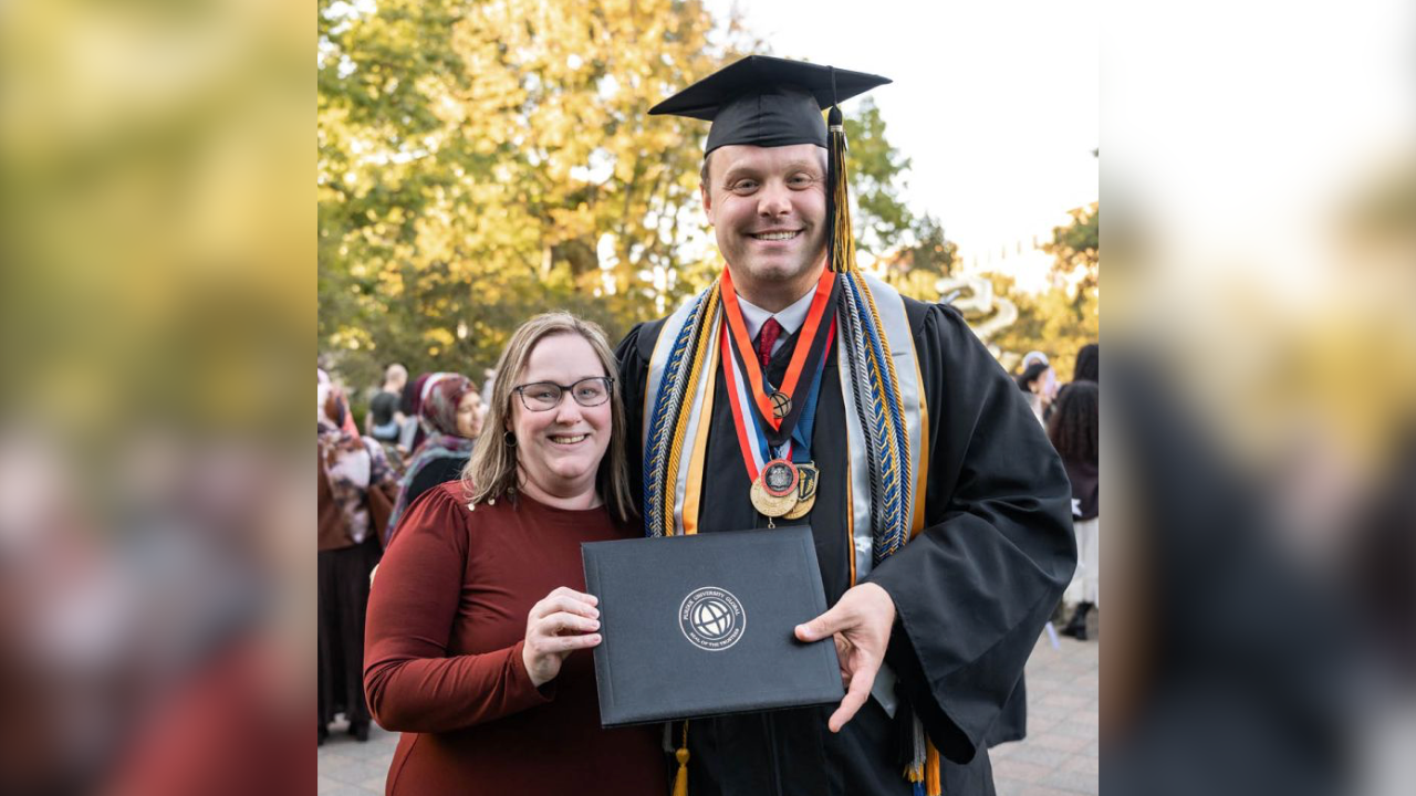 Kurtis shows off his diploma alongside his wife, Brittany