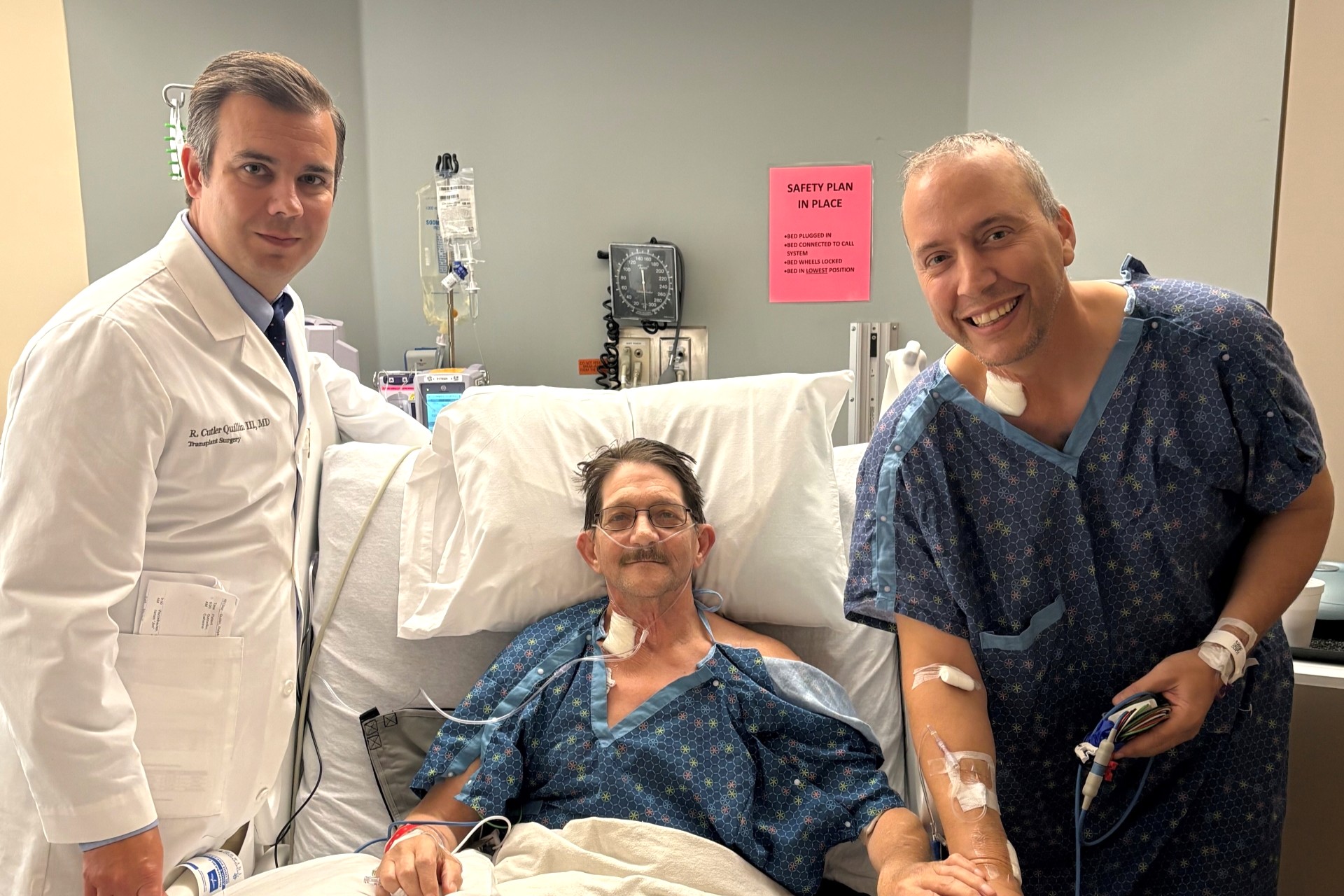 Physician stands next to patient and Mark in a medical setting. 