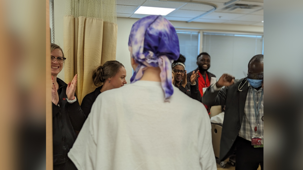 Mary's UC Health care team celebrates with her and her family as she rings the bell marking her final treatment.