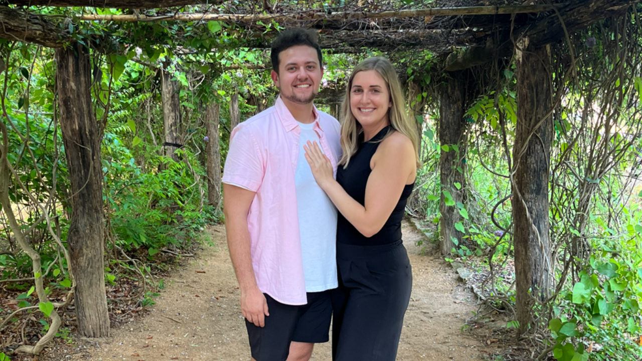 Mason and Hannah pose together under a trellis 