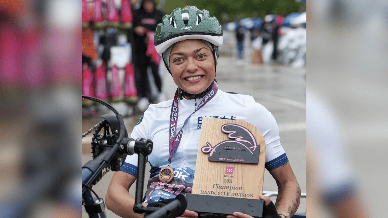 Mikiahya Greene in her helmet and adaptive chair, smiling on race day