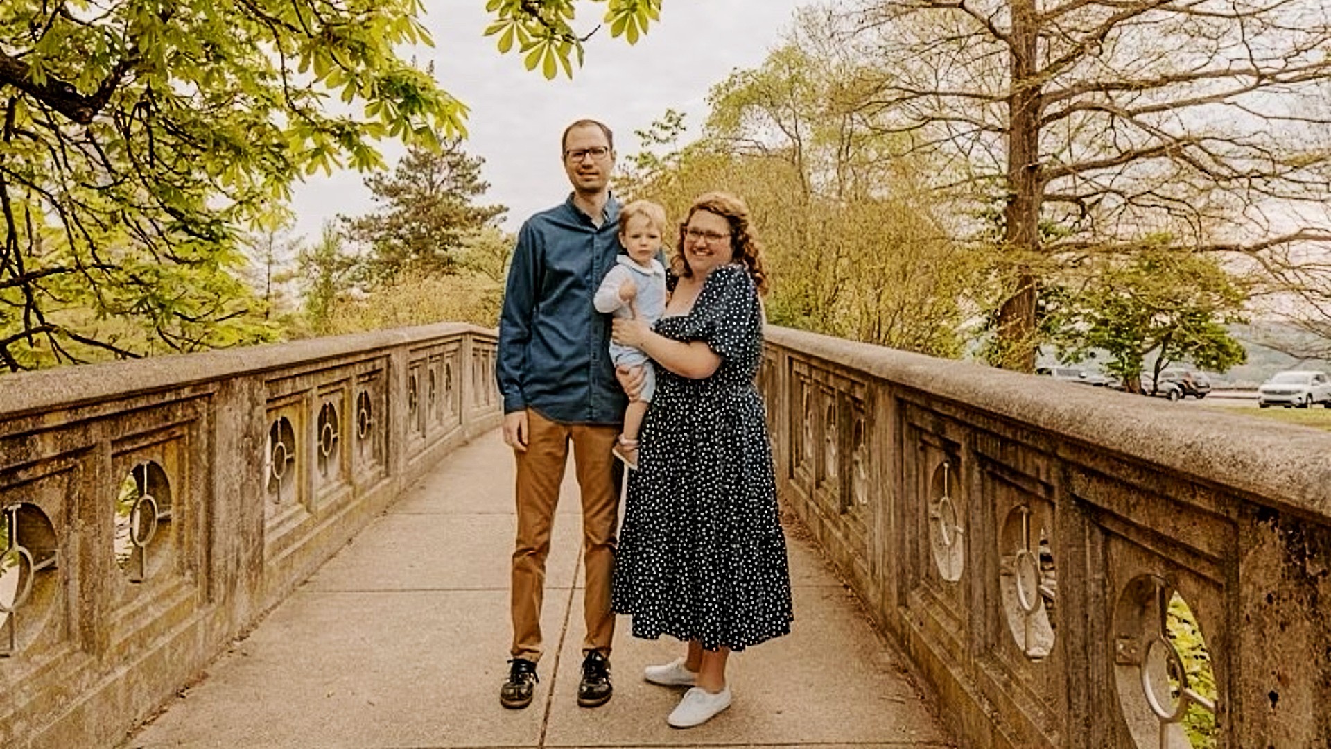 Patrick, Emma, and Wes Shoemaker on a bridge in a park. 