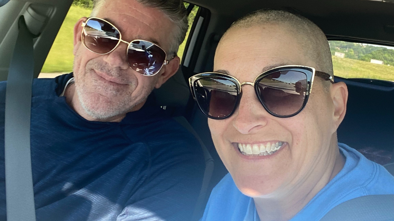 Patty Young and another passenger sit in a car and smile.