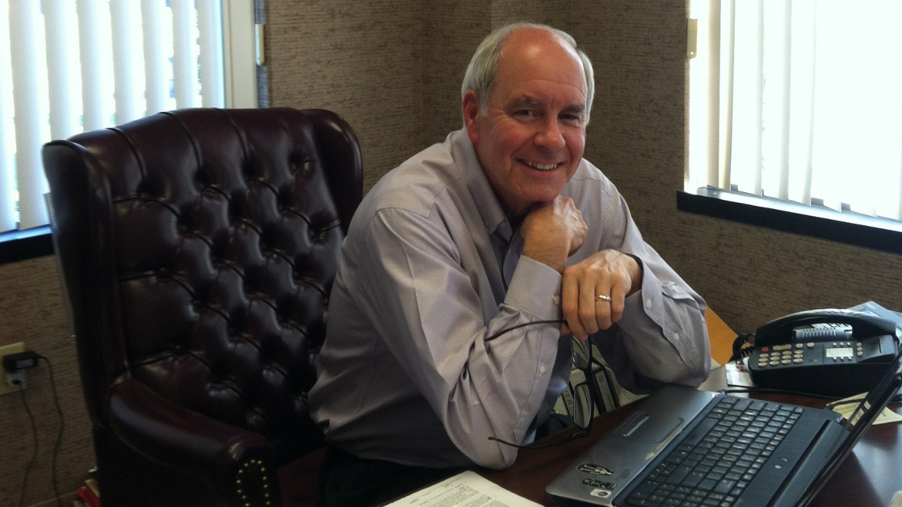 Rod Fussinger smiles while working in the office