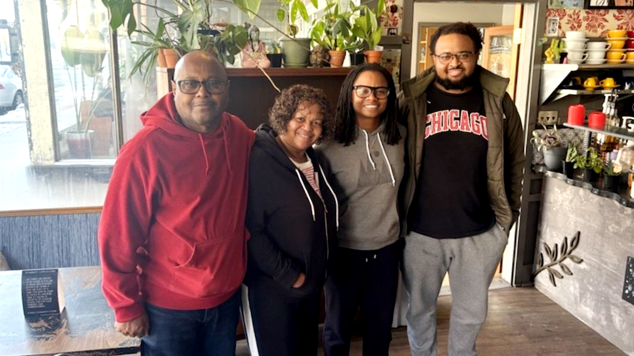Roslyn and Eric stands with two of their children in a restaurant.