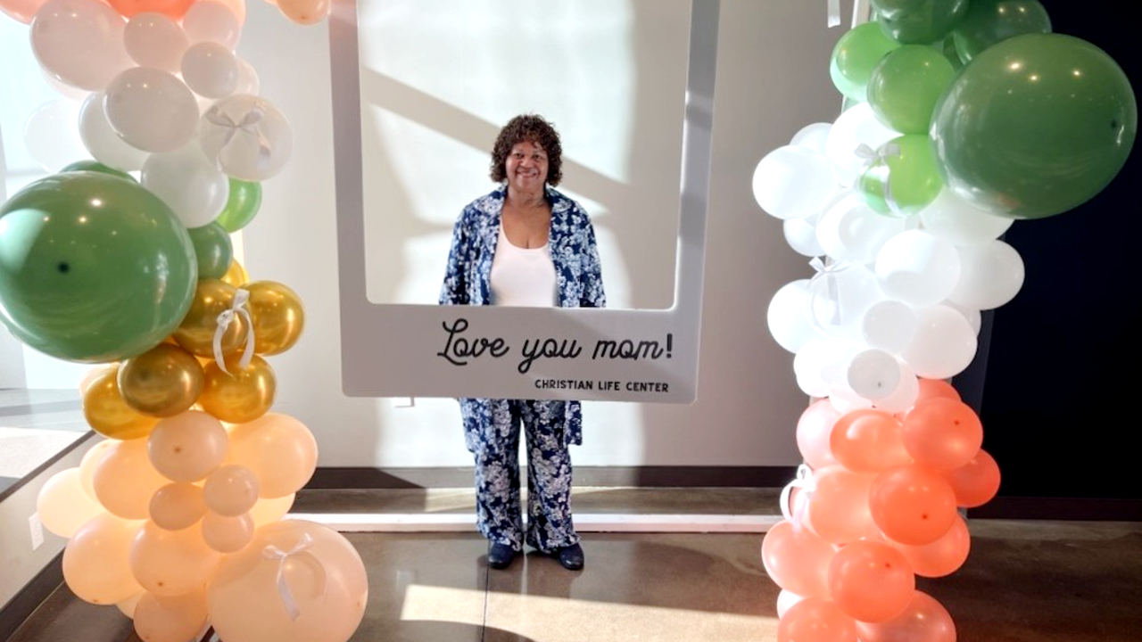 Roslyn stands in the middle of balloons. 