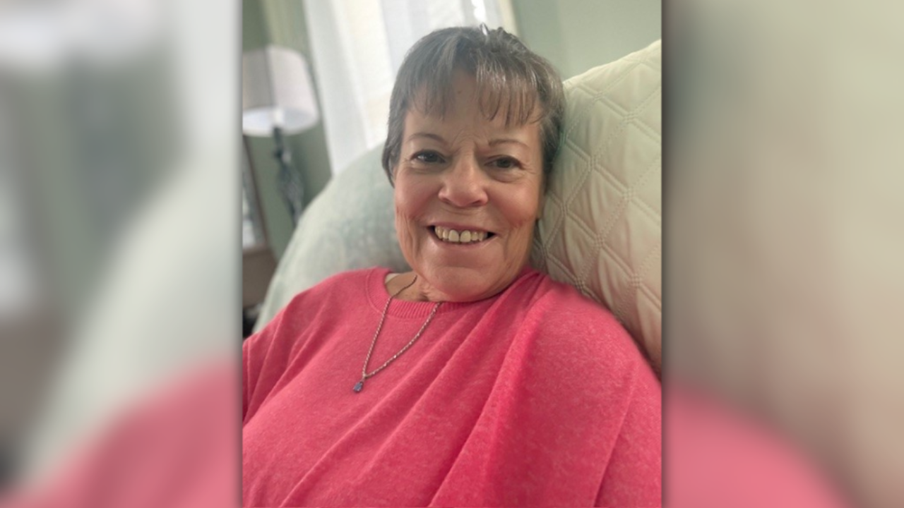 Tammy smiles from home in a pink sweater