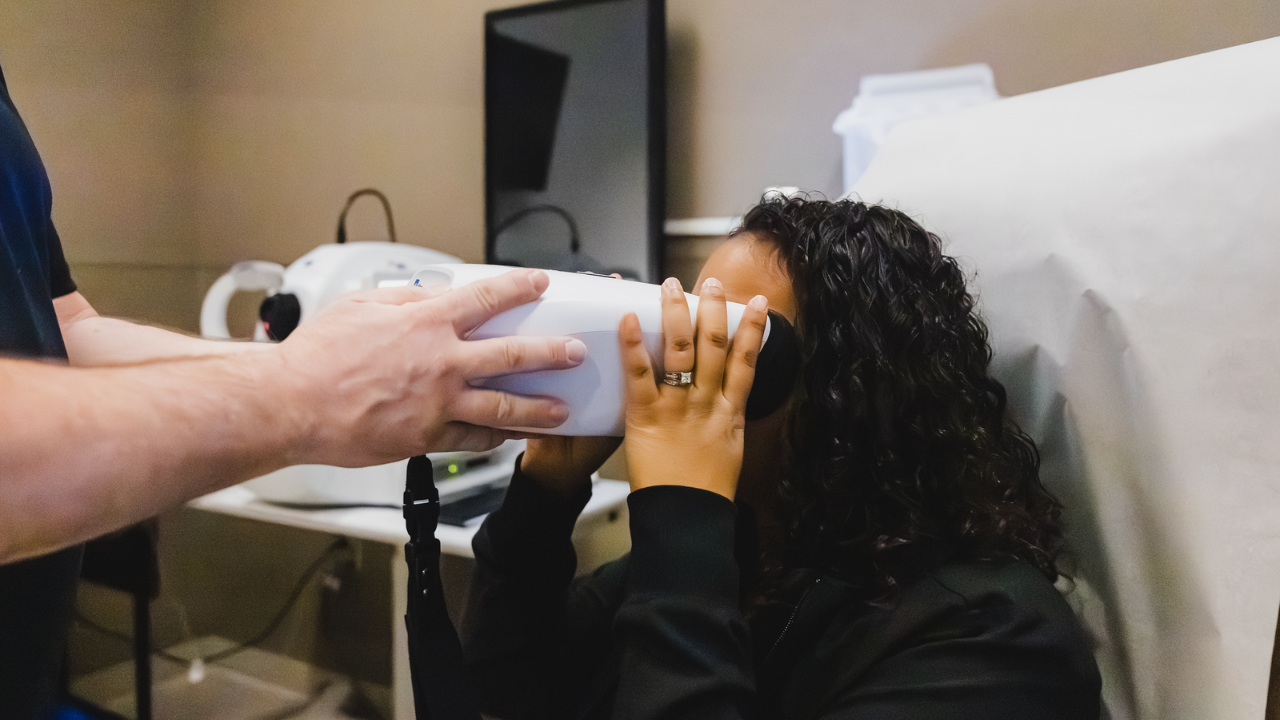 Woman uses portable fundus camera during testing in MS clinic
