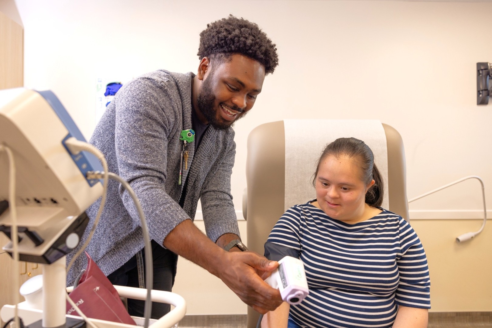 A medical provider shows a patient a medical device. 