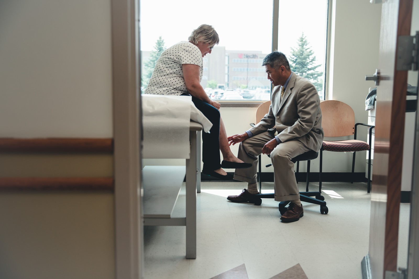 Physician examines a patient's ankle and foot.
