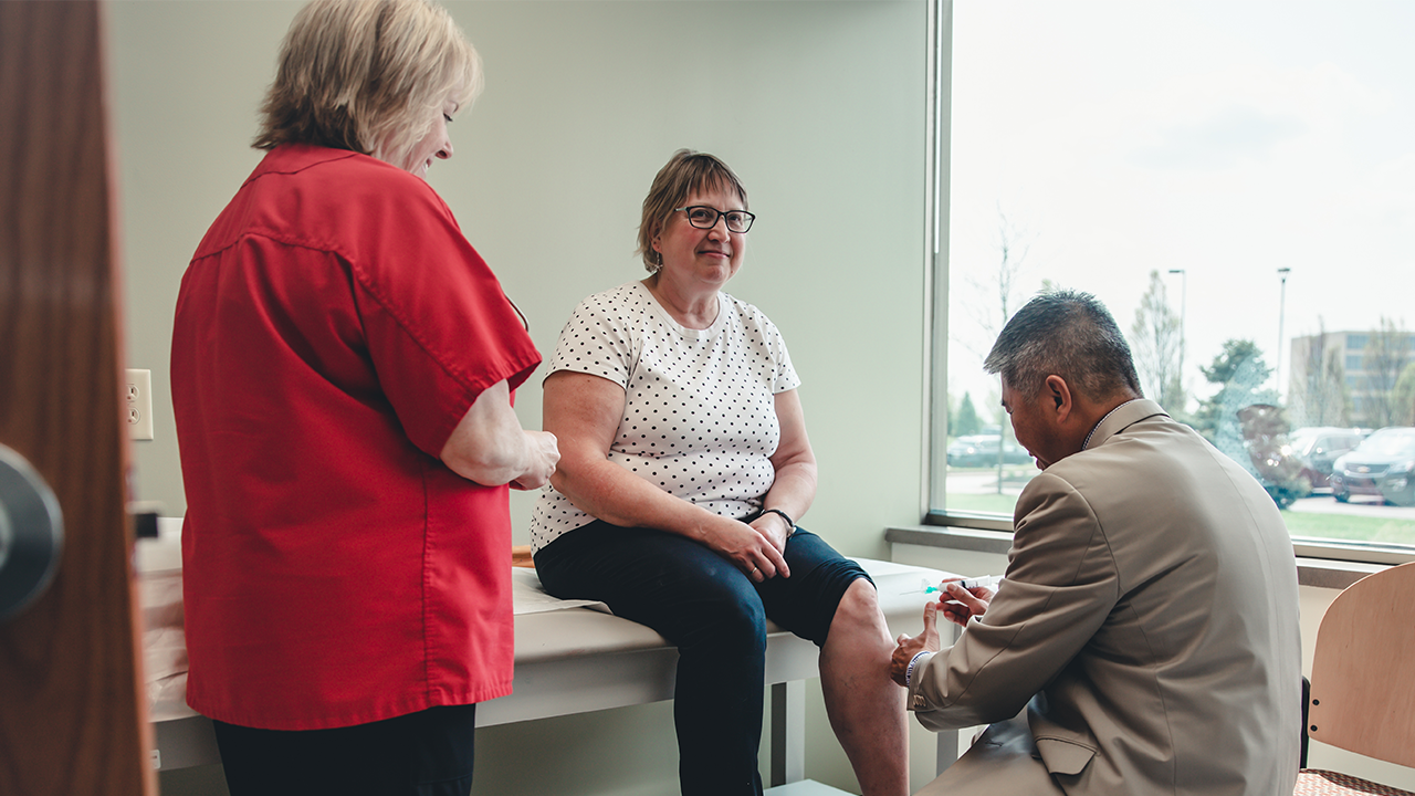 Physician works with a patient in a medical room. 