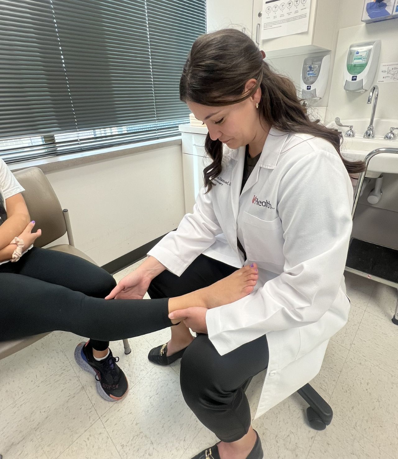 Dr. Hamad examines a patient's foot or ankle. 