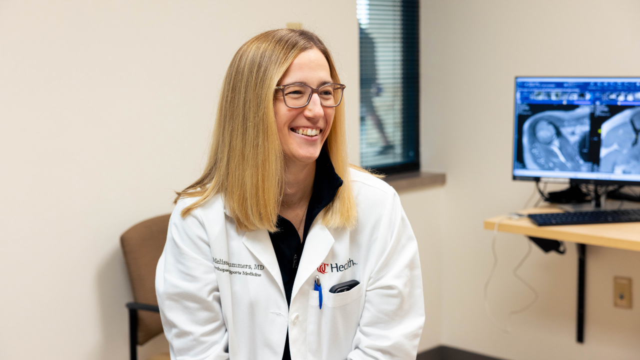 Physician talks with a patient in an exam room. 