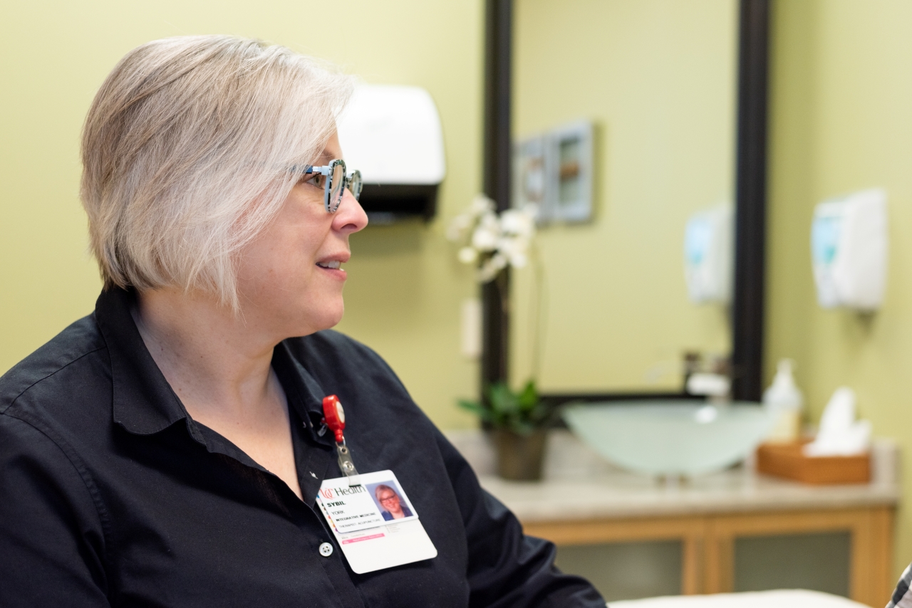 An acupuncture therapist talks with a patient. 