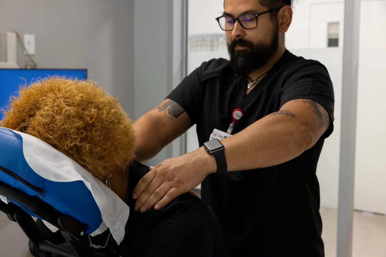 Therapist massages a client's shoulders.