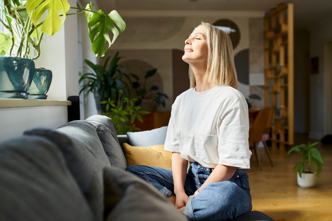 Woman practices meditation while looking up toward to the sunlight. 