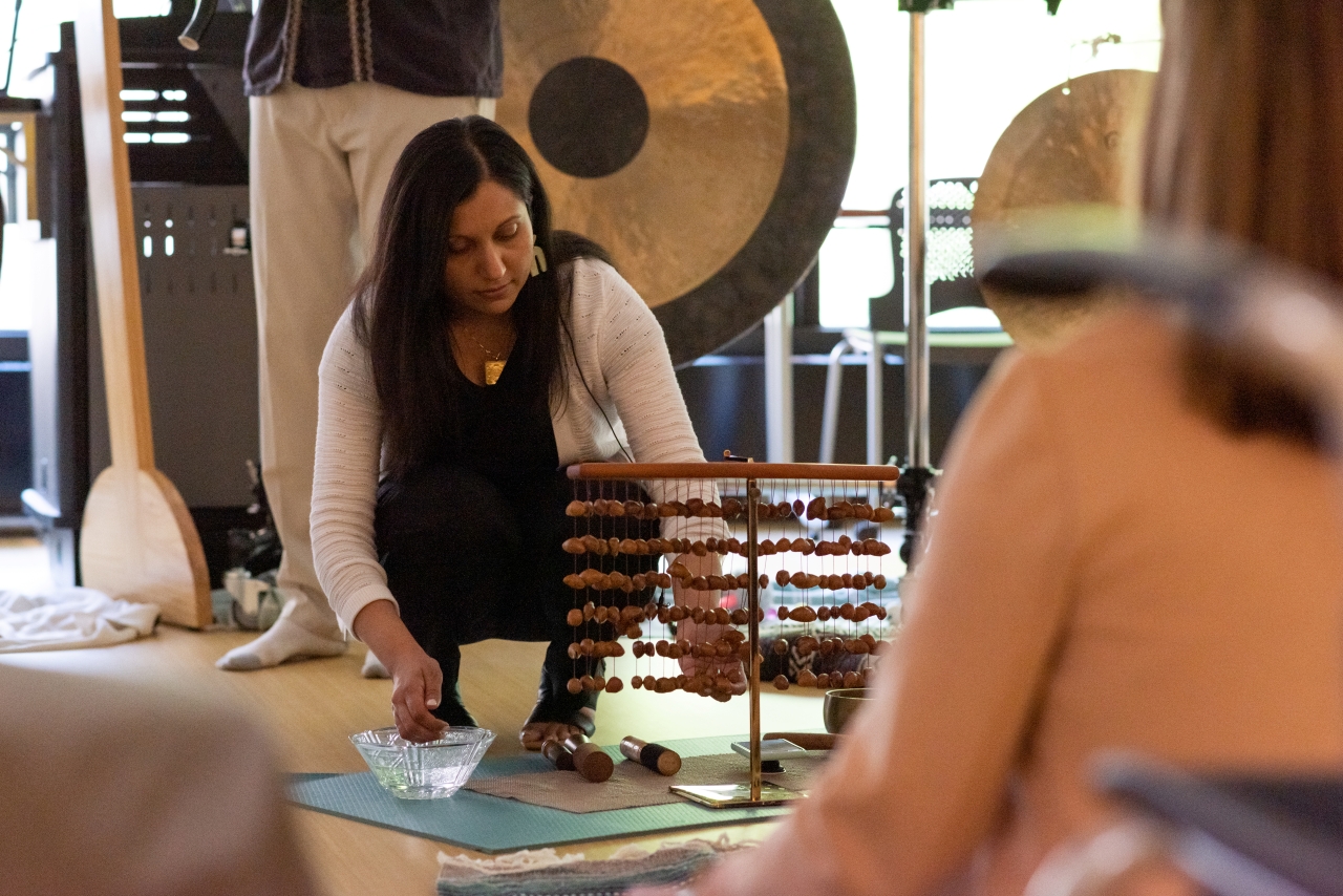 A woman uses instruments during a sound immersion session. 