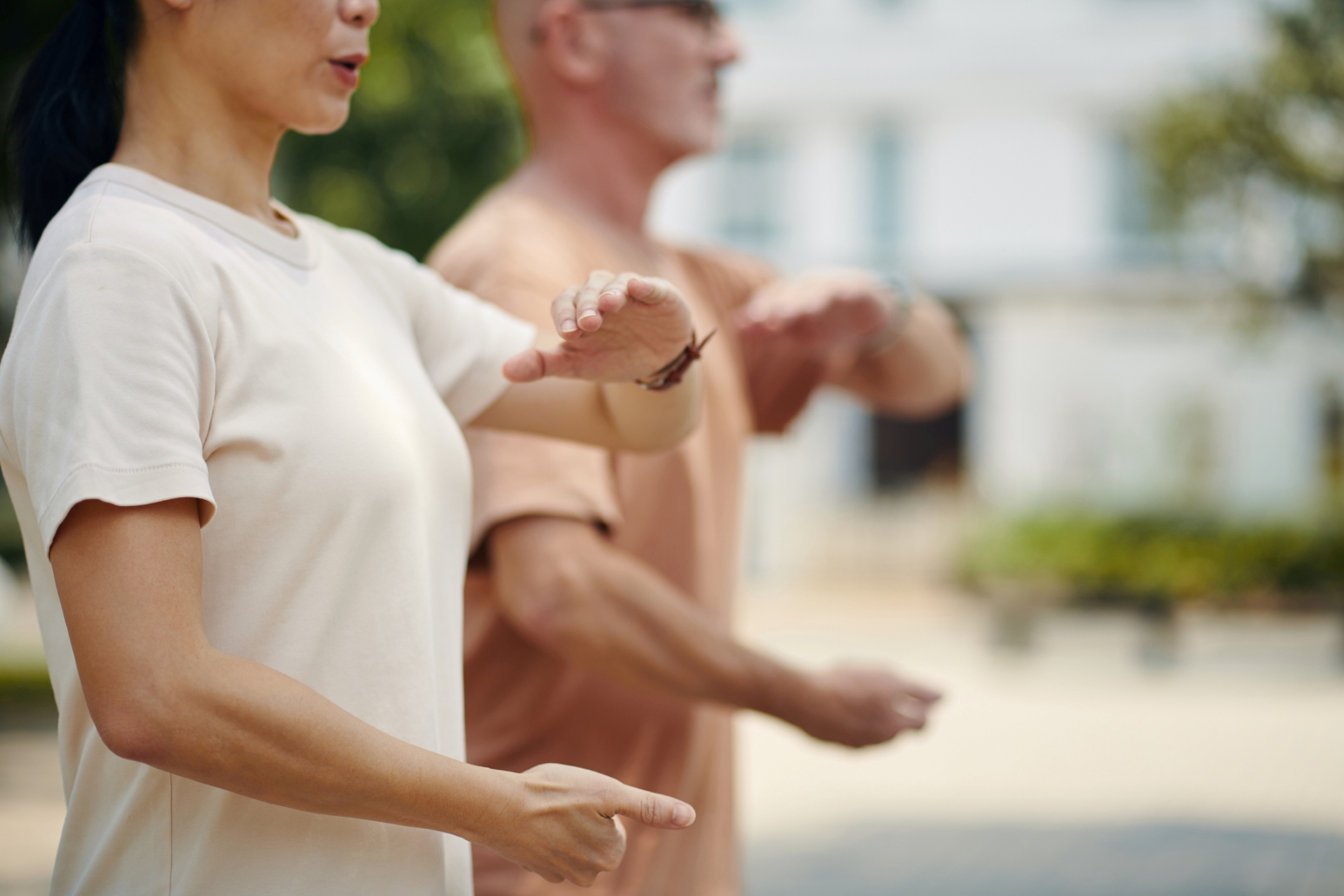 Two people practice tai-chi exercises. 