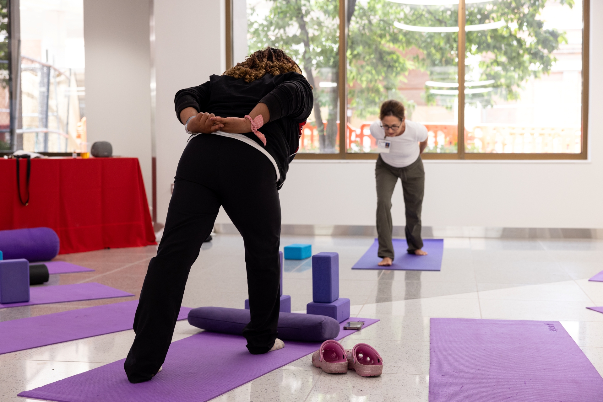 Practitioner guides a participant in yoga exercises. 