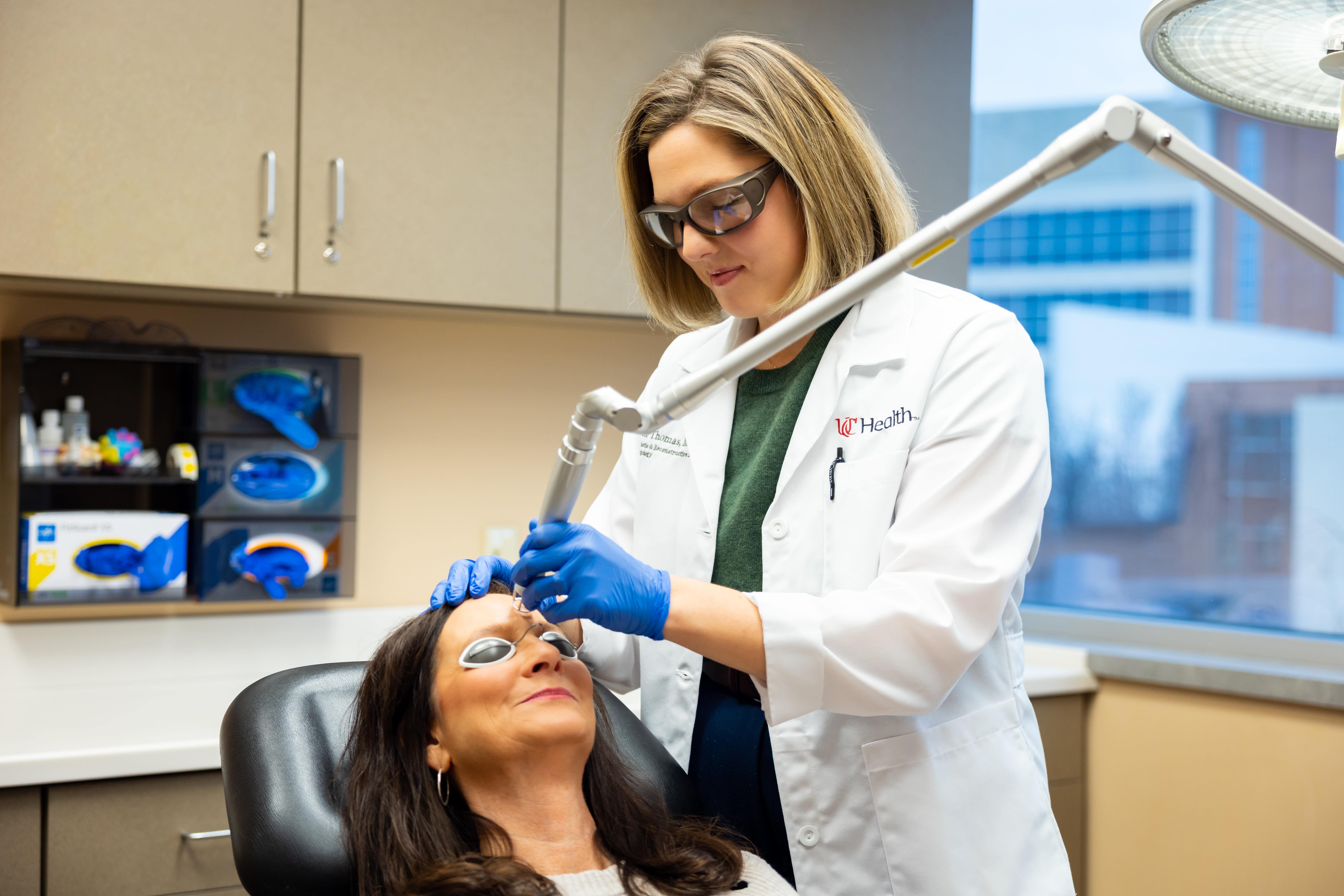 Dr. Thomas performs facial procedure on a patient in medical office