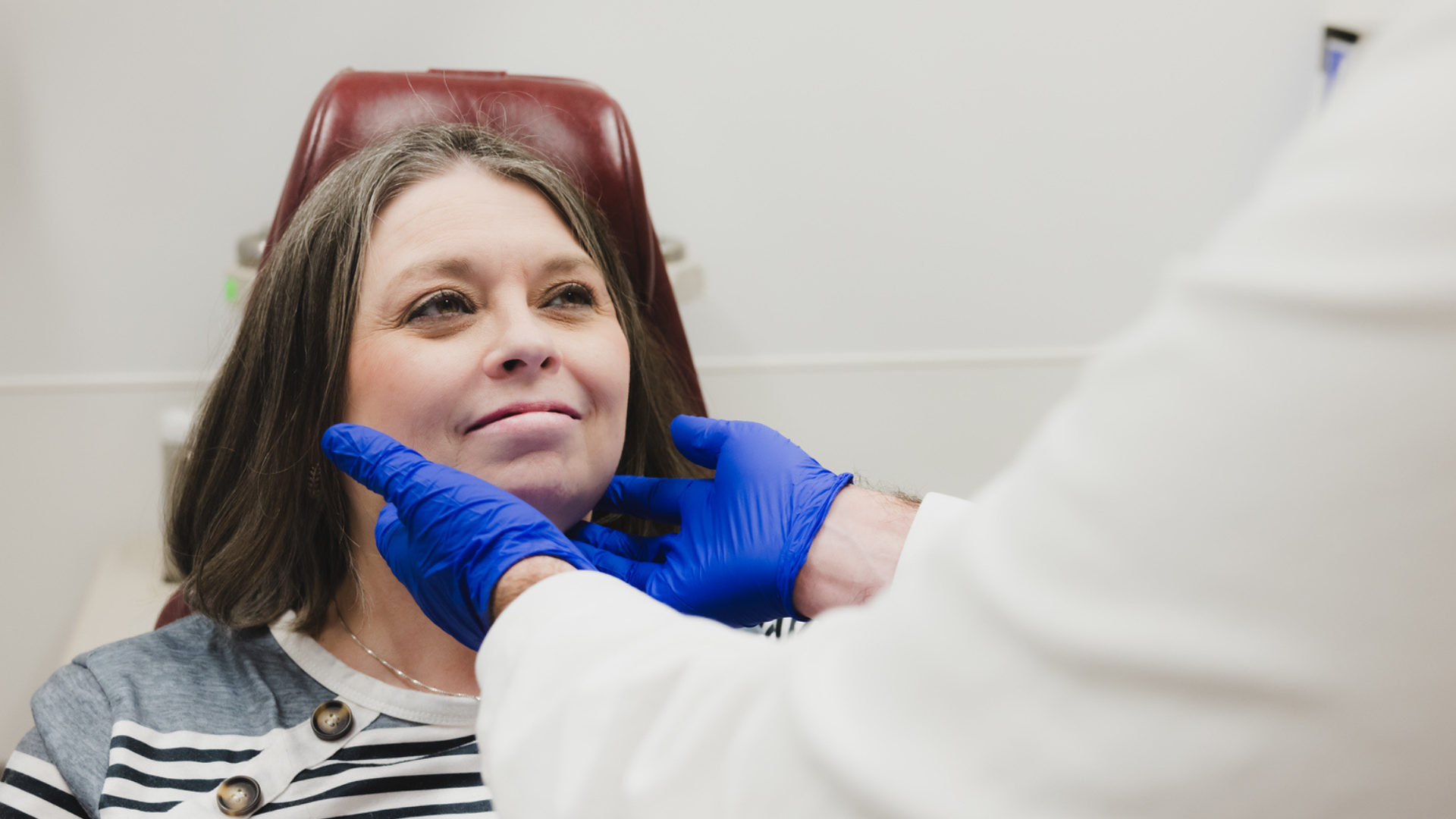 Physician conducts a head and neck exam on a patient