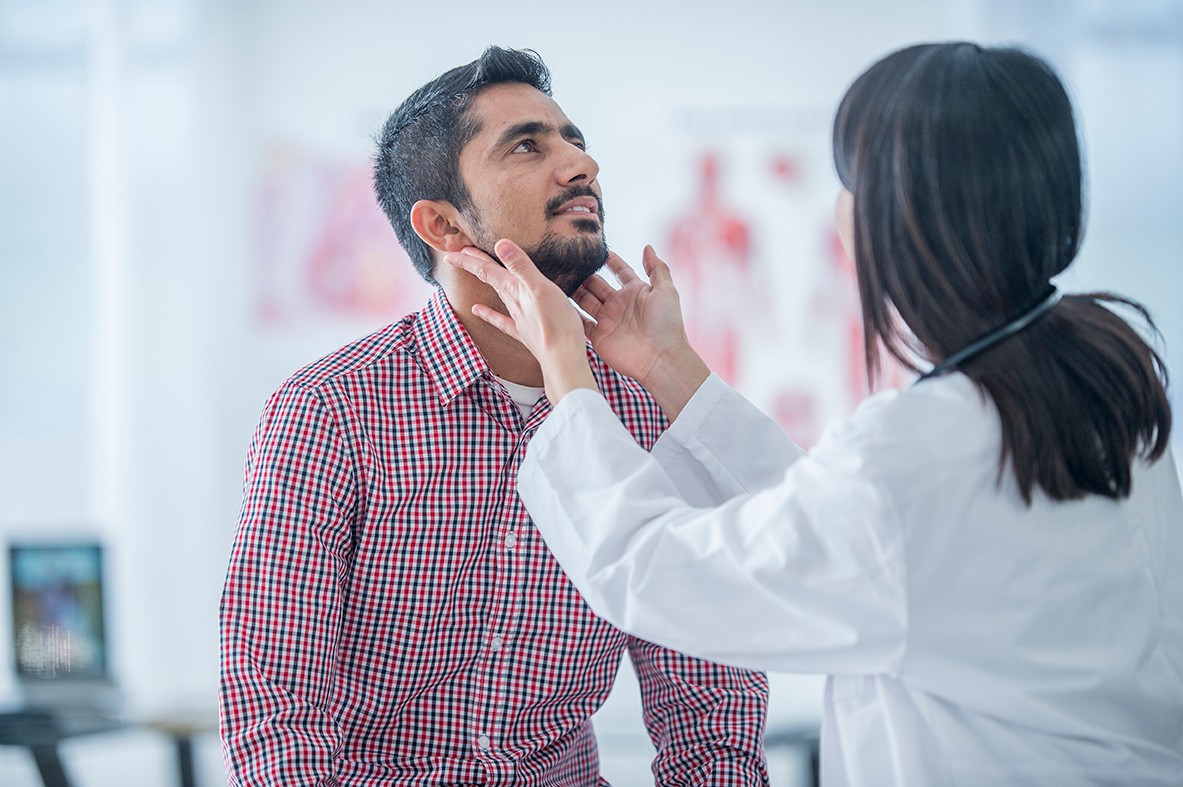 Physician examines a patient's throat.