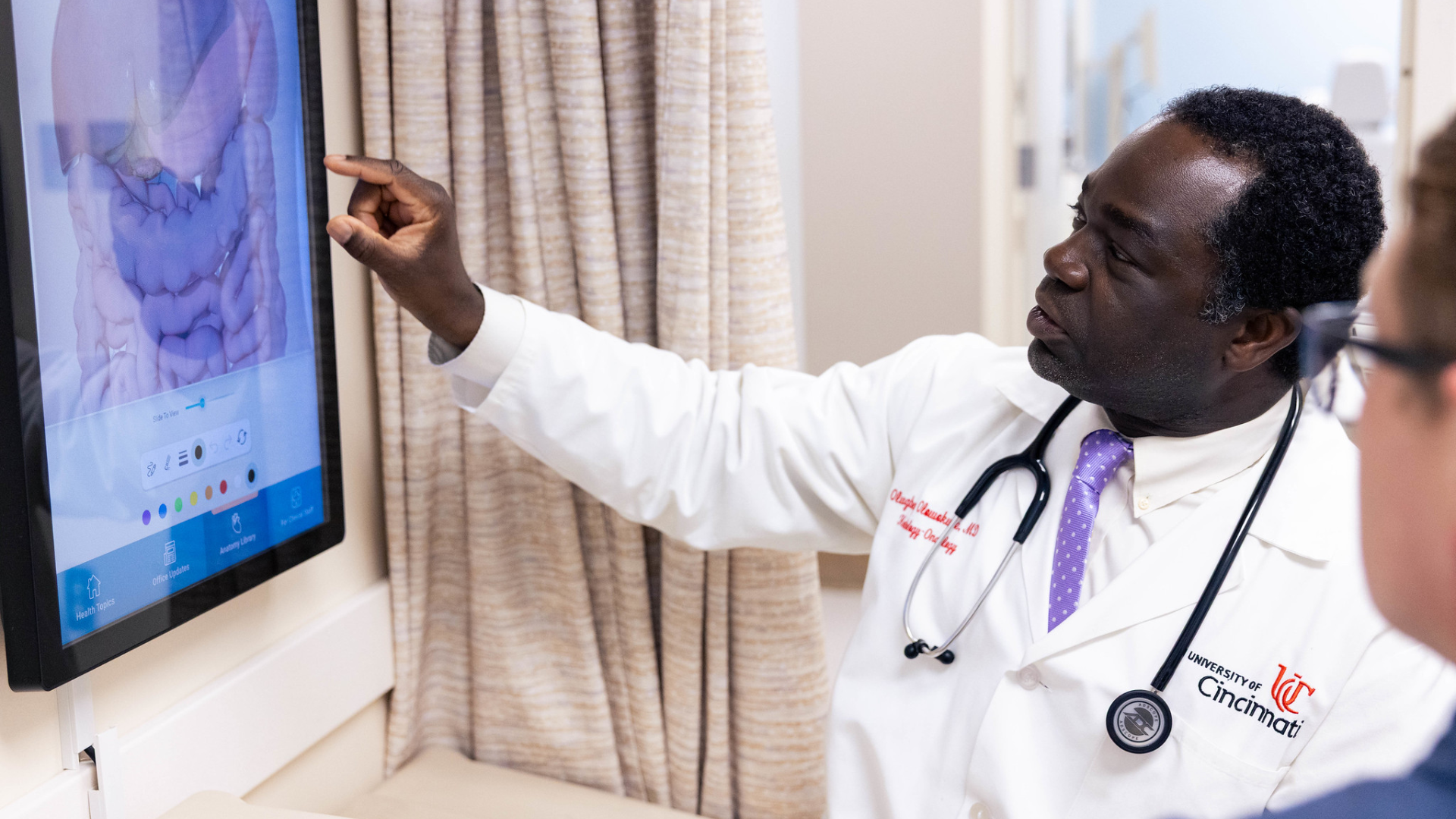 Dr. Benga Olowokure shows a patient the HPB system on a computer screen