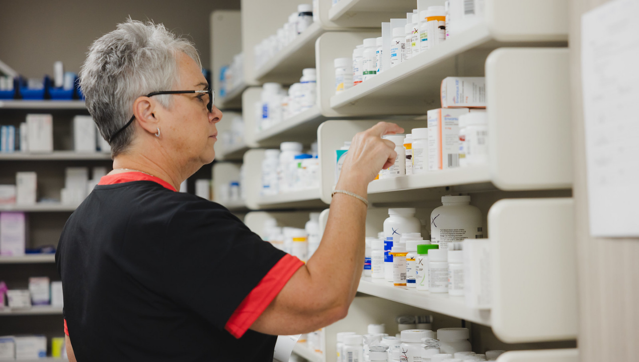 Pharmacist pulls prescriptions from the shelf