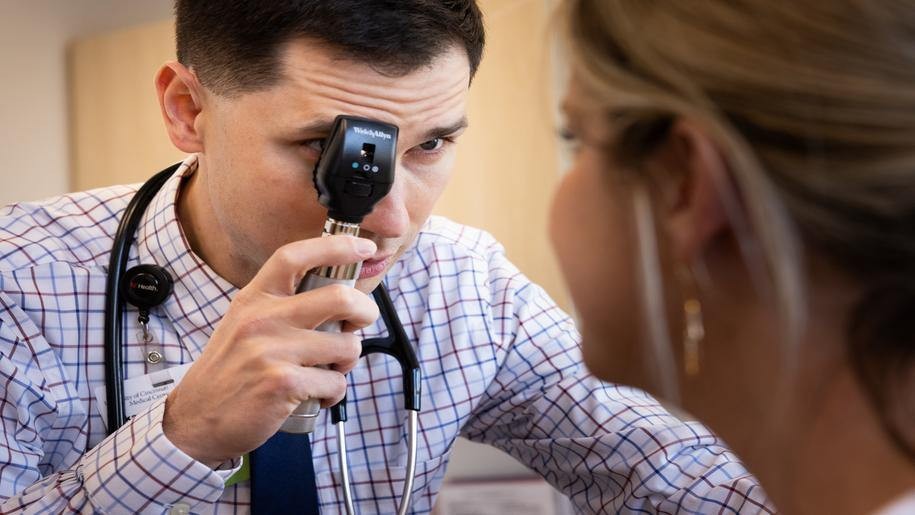 Medical provider examines the eyes of a patient. 