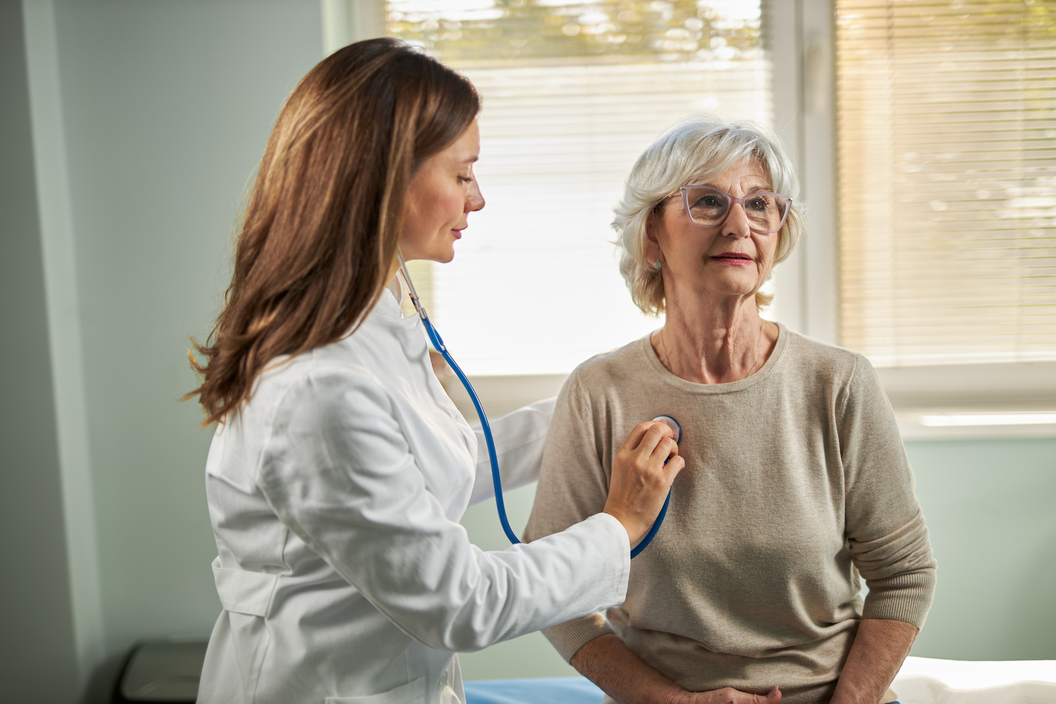 A doctor listening to a patient's lungs in the clinic.
