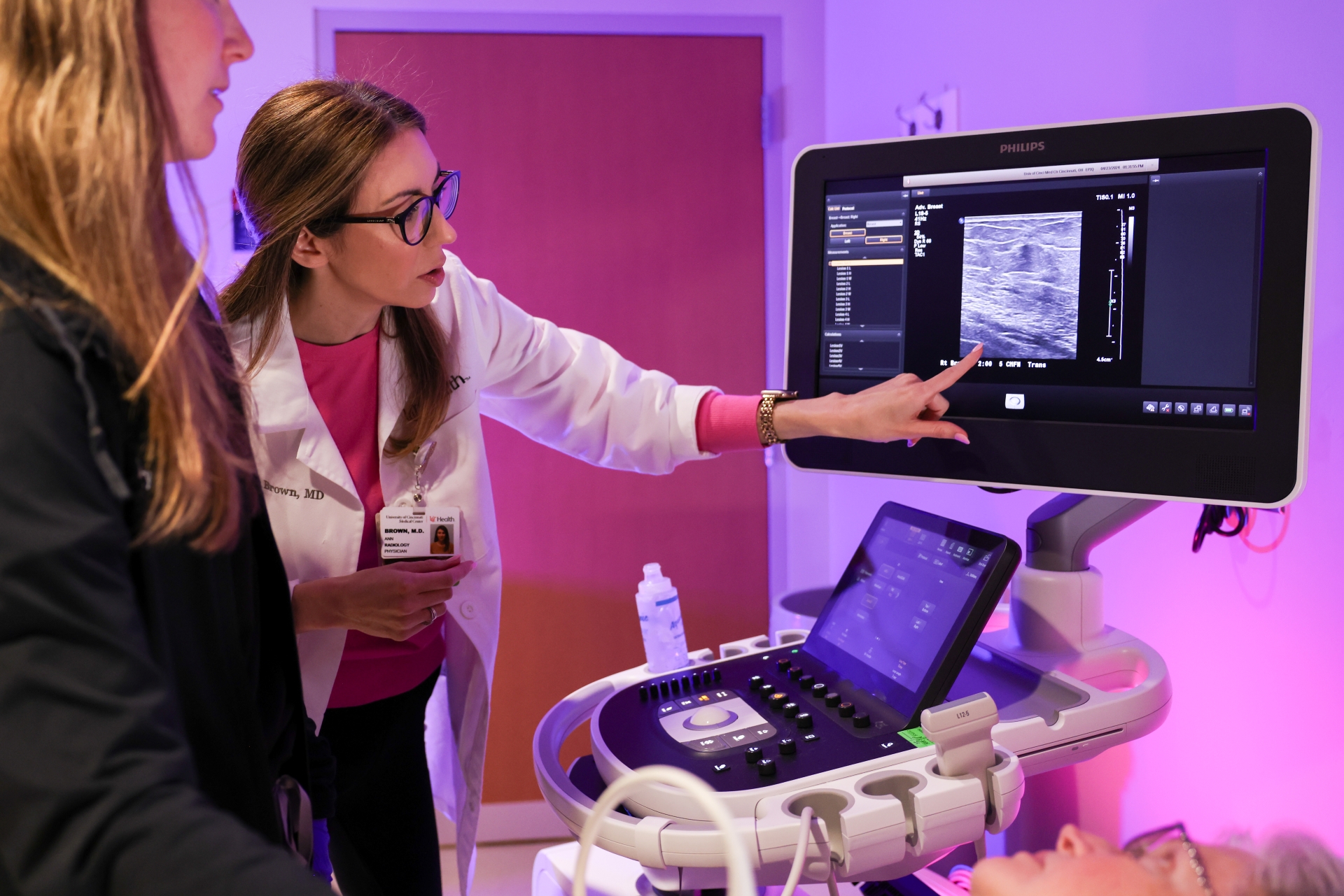Two medical practitioners study an image on a monitor. 