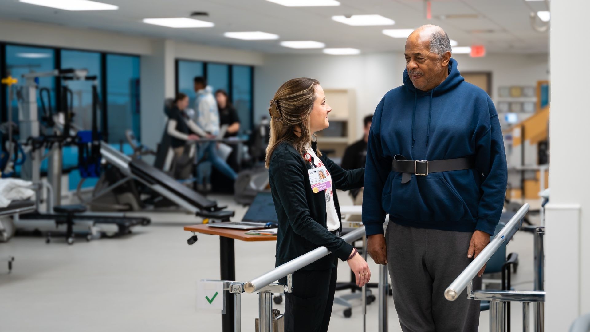 Medical provider attends to a patient on a physical therapy machine.