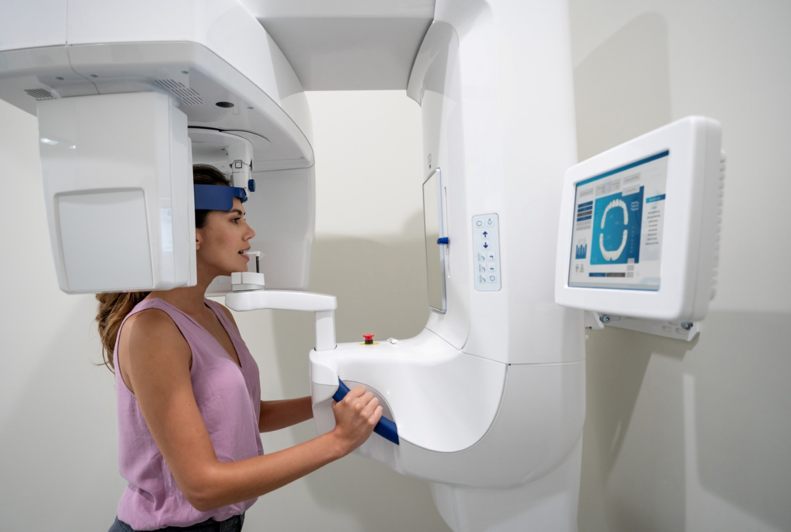 Woman stands in a cone beam machine for imaging. 