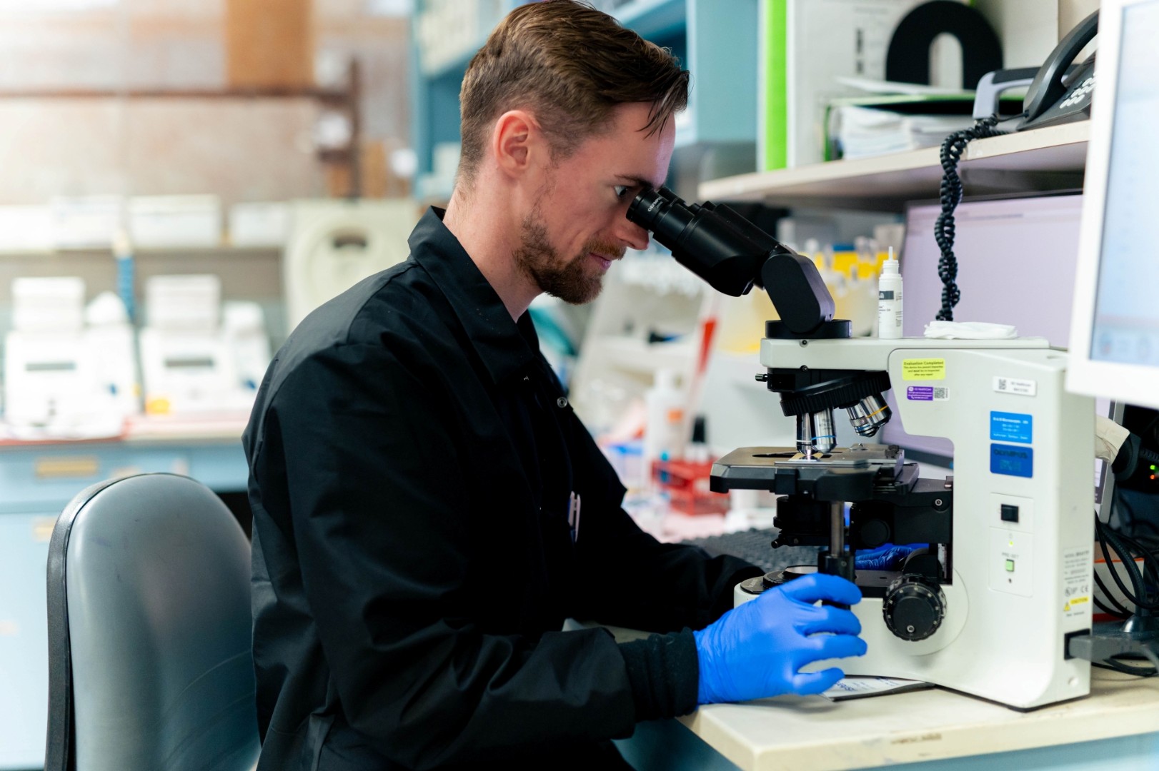 Medical provider looks into a microscope. 
