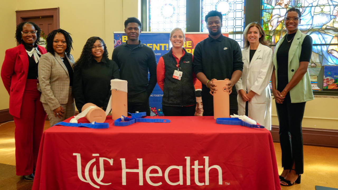 Group smiling in front of the Stop the Bleed education booth.