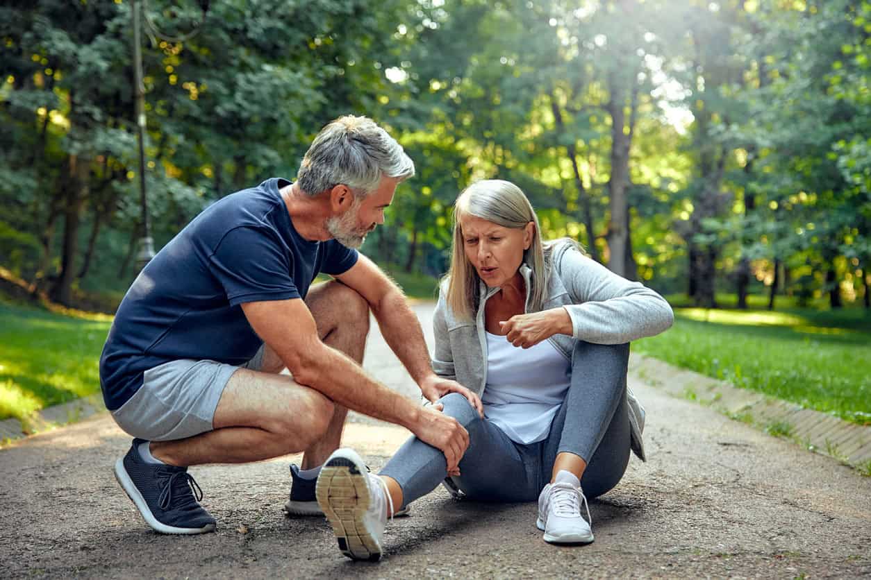 Older adult woman falls in the park. 