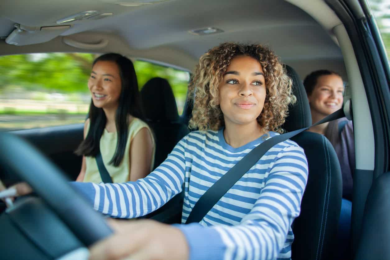 A group of teens driving safely.