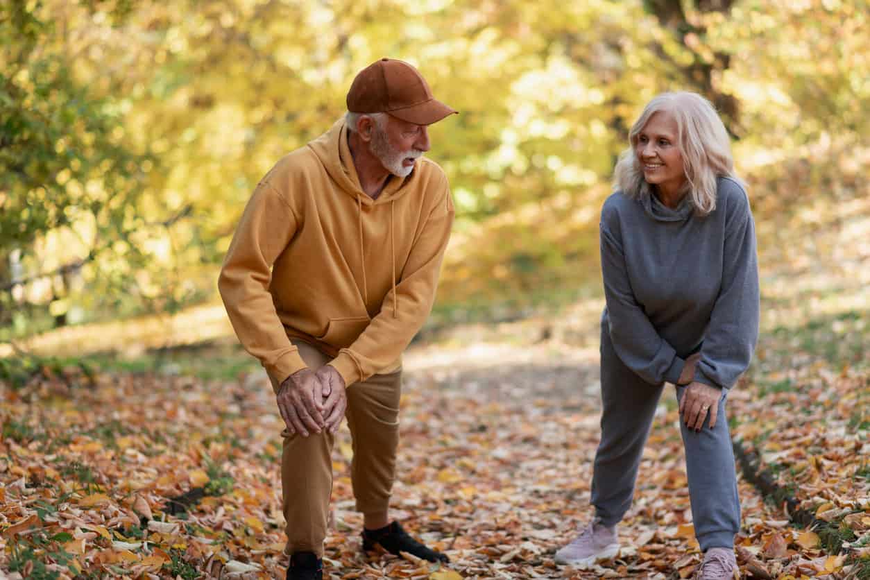 Older adult community members stretching in the park.