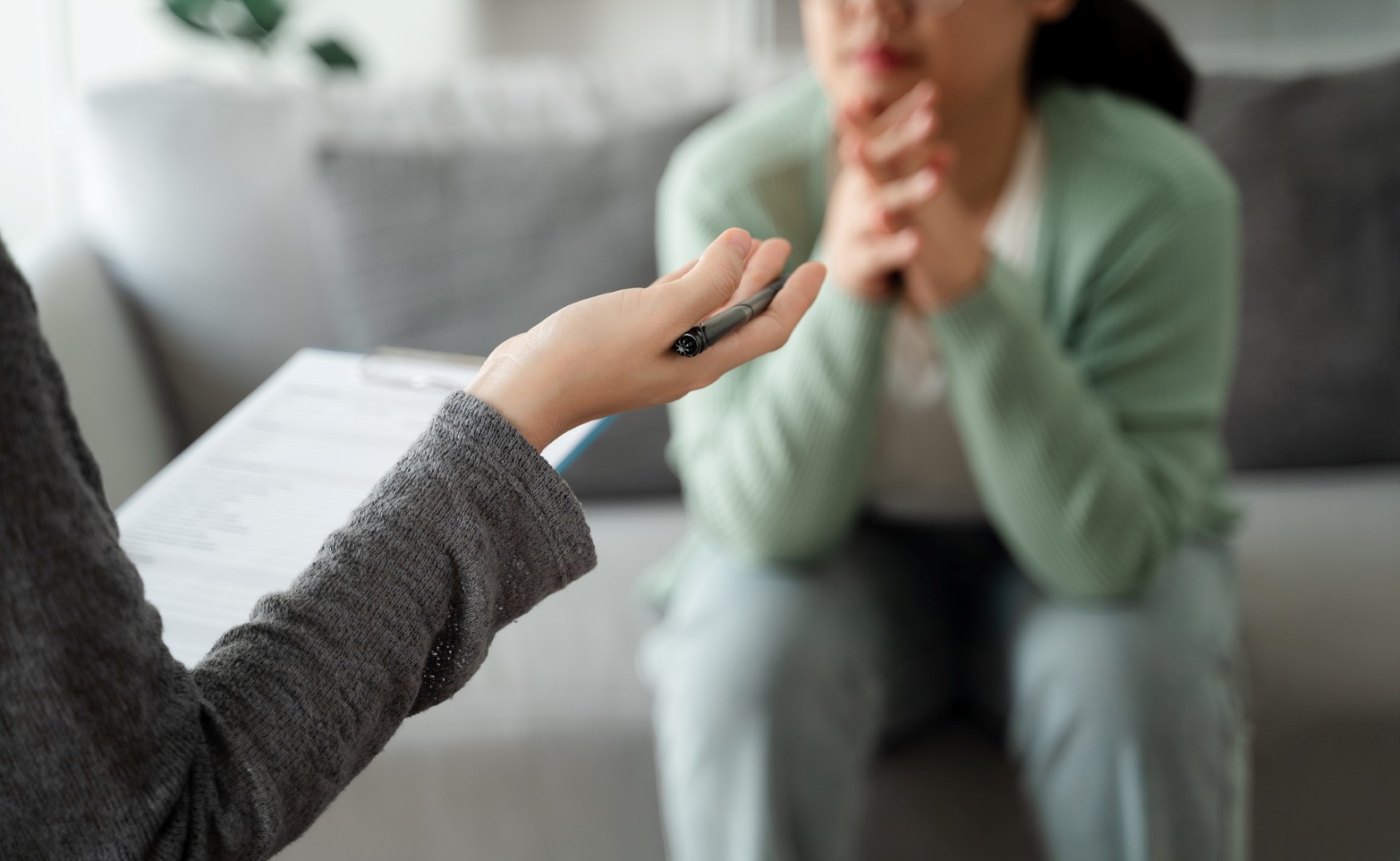 Woman sits on a sofa in a therapy session. 