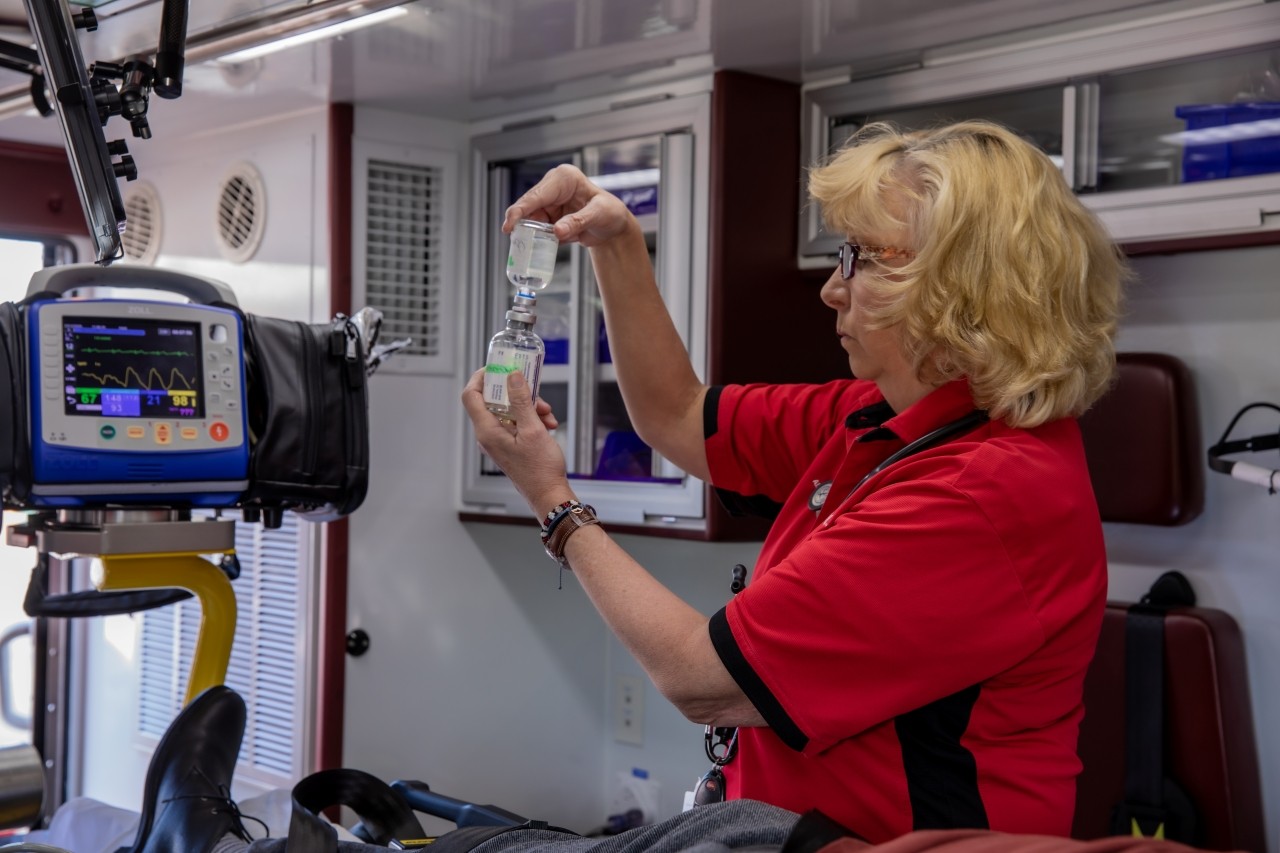 A medical provider within a mobile care unit looks assists with a patient.