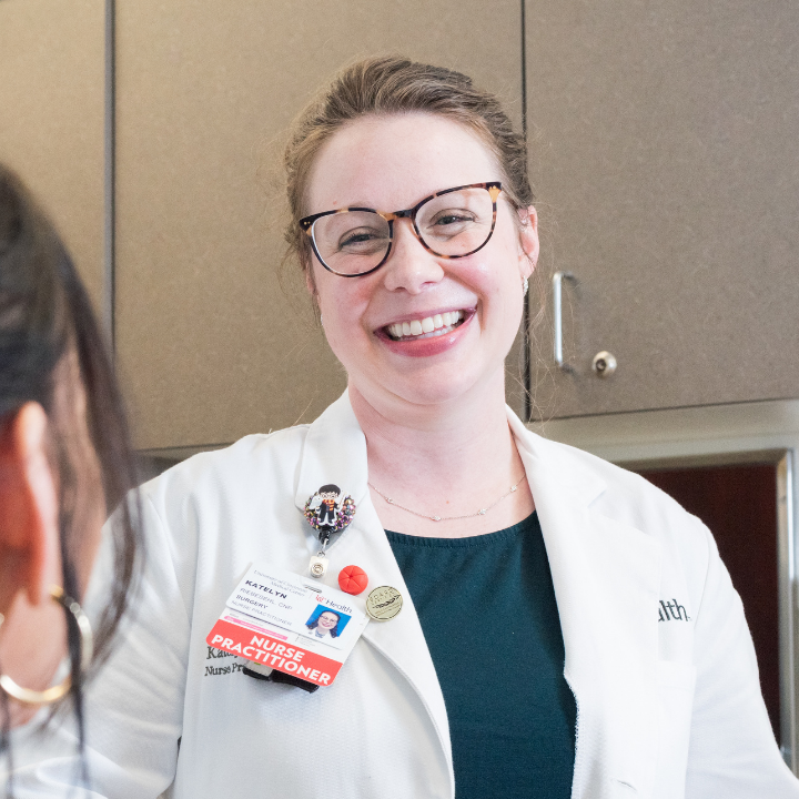 Physician smiles as she talks with a patient. 