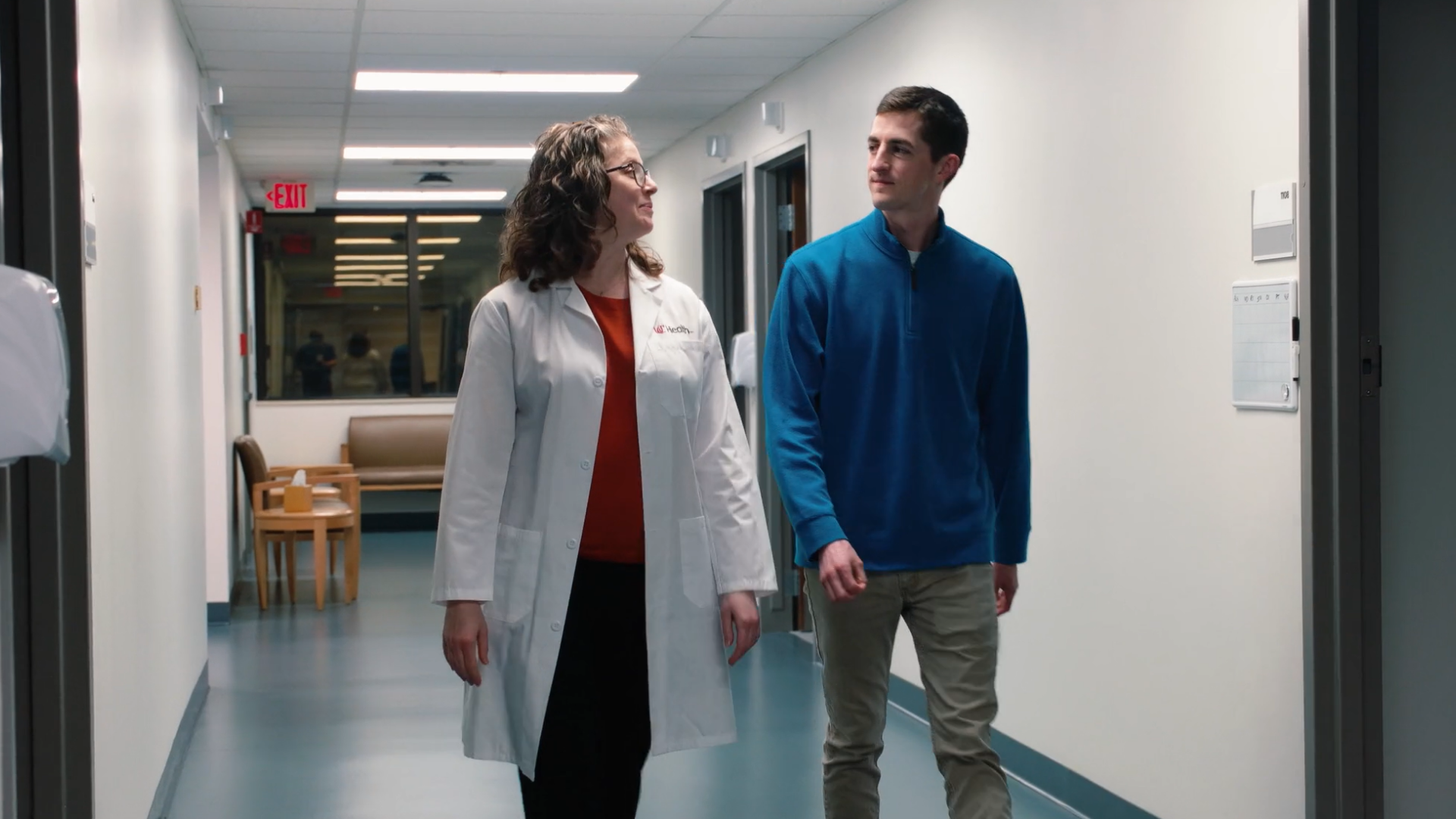 Nurse navigator and patient walk through the hallway together at UC Health