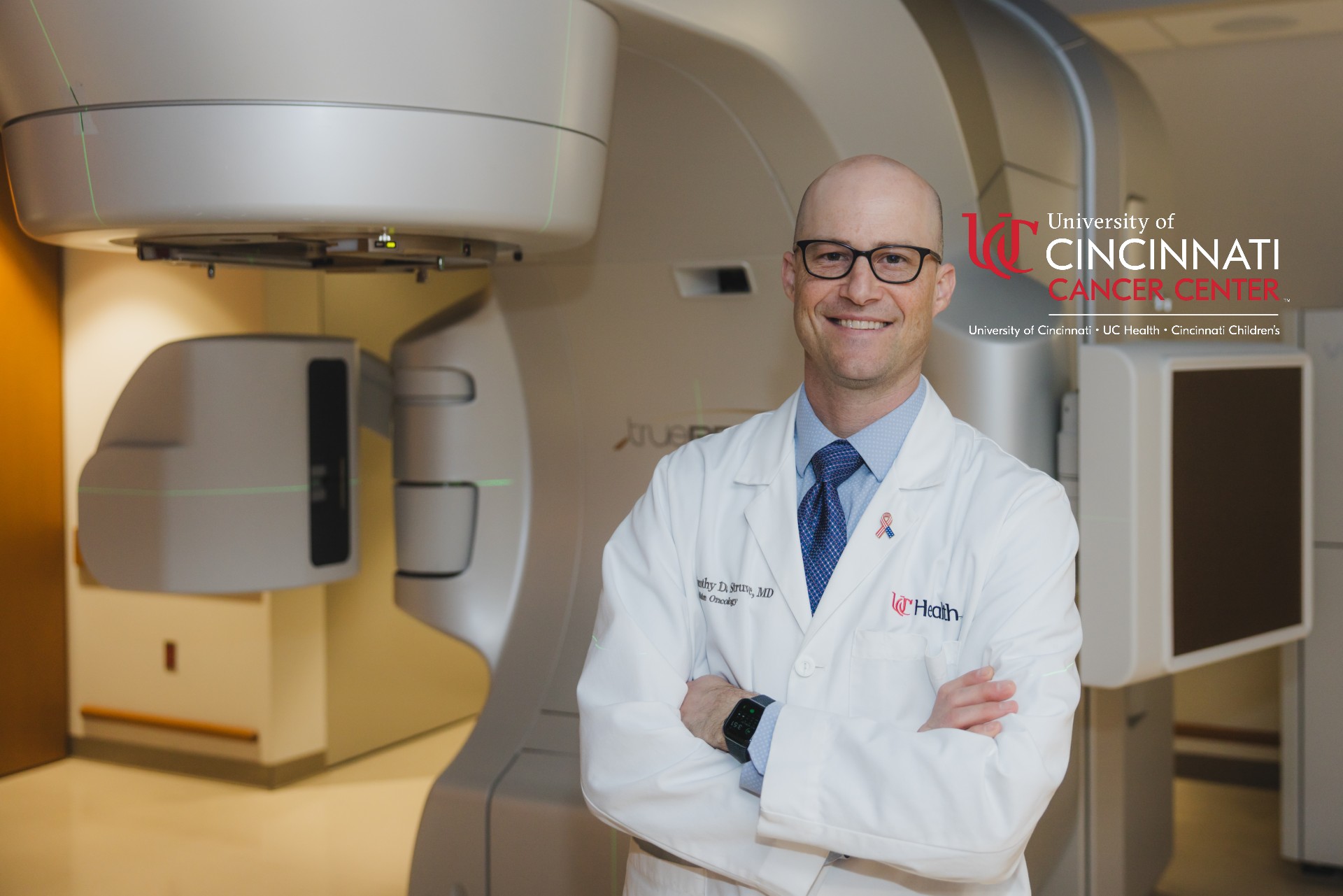 Physician in front of Varian beam proton therapy machine.