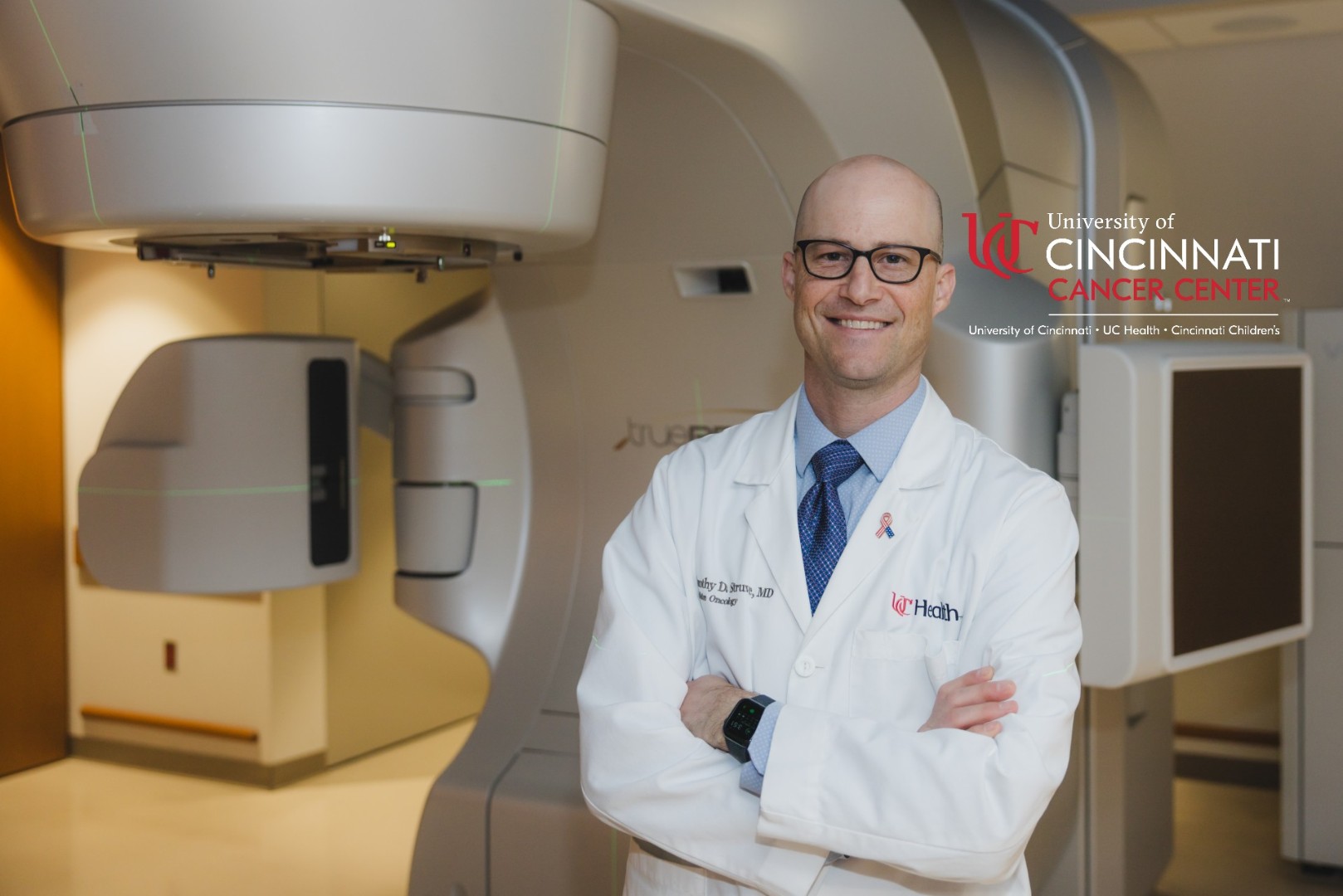 Physician in front of Varian beam proton therapy machine.